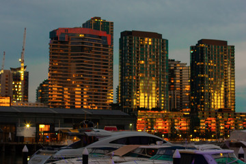 Fototapeta premium A view of the night Melbourne. Quay in Docklands, view from the bay to the skyscrapers with yachts in the foreground.