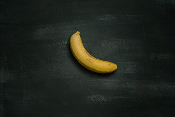 Art installation banana taped to a black wall 