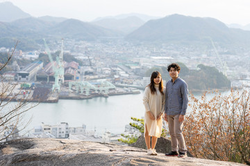 Naklejka premium 尾道水道を背にする若い男女のポートレート