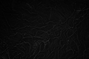 Very dark black wall surface, background.
