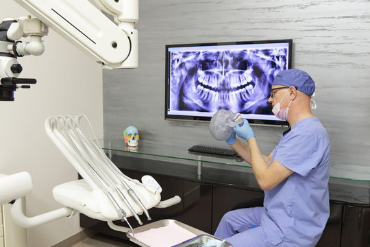 Middle age dentist preparing treatment plan in his office