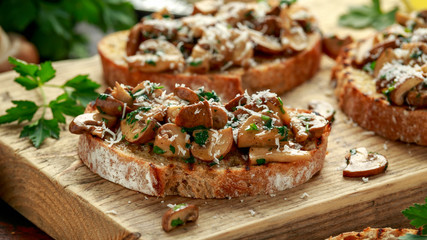 Grilled mushroom toast with parsley, lemon and parmesan cheese on wooden board. healthy vegan food - obrazy, fototapety, plakaty