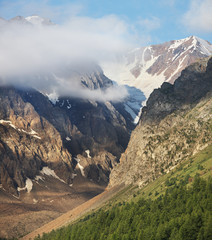 Mountain peaks in the clouds. Travel and vacation in the mountains.