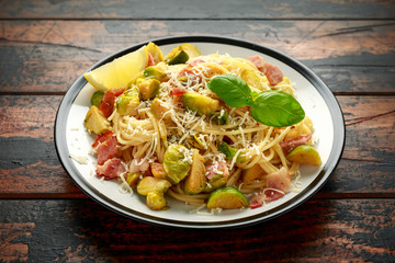 Homemade Brussels sprouts, bacon, pancetta pasta with parmesan cheese. On wooden table