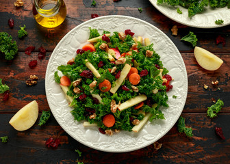 Kale salad with dried cranberry, carrots, walnuts and apple. healthy vegan food.