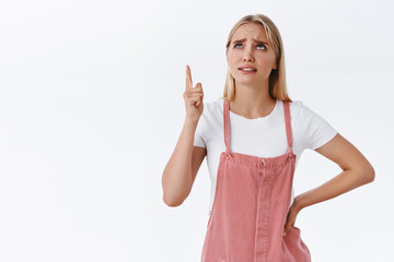 Girl see strange, unreasonable price for goods, looking skeptical and sipleased. Attractive blond...