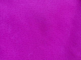 Background with leather texture. Violet piece of natural tanned calfskin painted and treated with fuchsin paint. Lots of detail, frontal shot with macro lens. Copyspace for border or frame