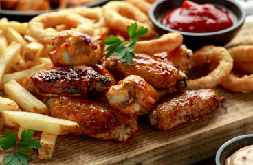 Fried Chicken wings with onion rings, french fries and dipping sauce. take away food.