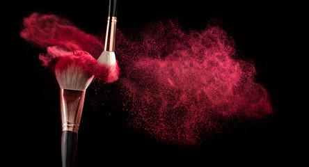 powder explosion with make-up brush on black ground