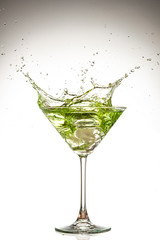 martini glass and splash from falling ice on a white background