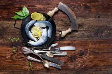 Close-up of fresh marinated fish served with onions on a rustic wooden table