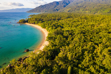 Aerial view of remote beach squeezed between coral reef and primary rainforest, Tampolo, Masoala...