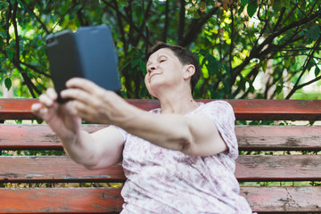 Naklejka premium Senior woman taking selfie outside