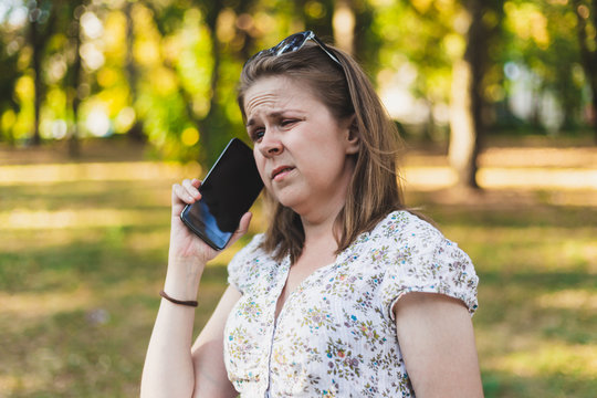 Young woman talking on a mobile phone outside