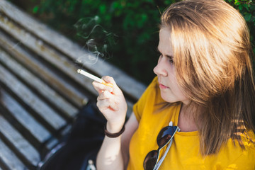 Pretty teen girl smoking outside