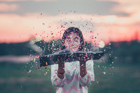 CLOSE-UP OF GIRL WITH CONFETTI AGAINST SKY