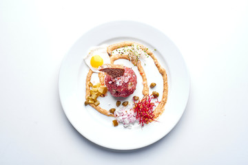 Tartare with egg. Set Food Menu On A White Plate. Top view of light dish perfect served.