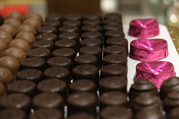 Assorted candies in the candy store. Chocolate cookies and pink heart