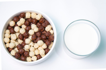 Glass of milk with a plate of cereal on a white background.