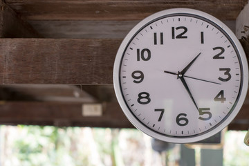 A wall clock that was hung at an antique wooden house