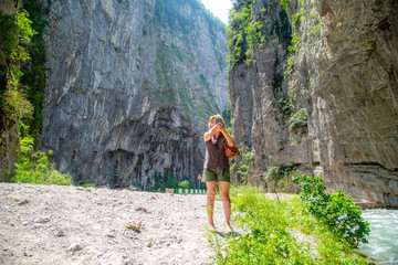 Obraz premium young woman makes selfie on the background of rocks