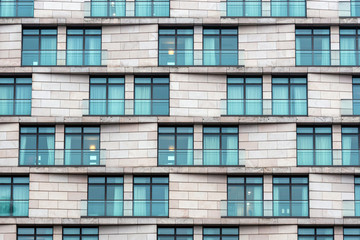 Close-up of the facade of a modern high-rise stone building © ako-photography