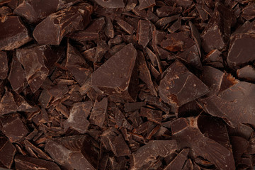 Chipped Dark Chocolate Pattern. Background of chocolate pieces.