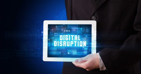 Young business person working on tablet and shows the digital sign: DIGITAL DISRUPTION