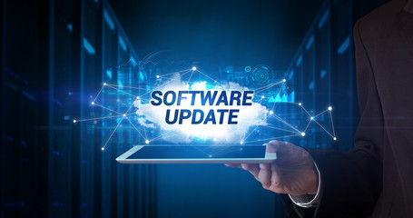 Young business person working on tablet and shows the inscription: SOFTWARE UPDATE