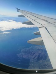 Obraz premium wing of an airplane flying above the clouds