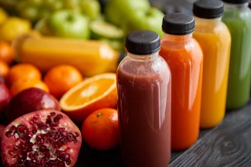 Plexiglas foto achterwand Kleurrijke flesjes gevuld met vers fruit- en groentesap of smoothie © Dash