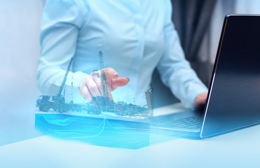 a hologram on a laptop, drilling a well to monitor and analyze geology in oil and gas production. Modern technology and artificial intelligence