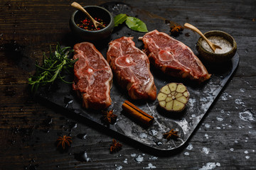 Lamb meat on stone tray on dark concrete background