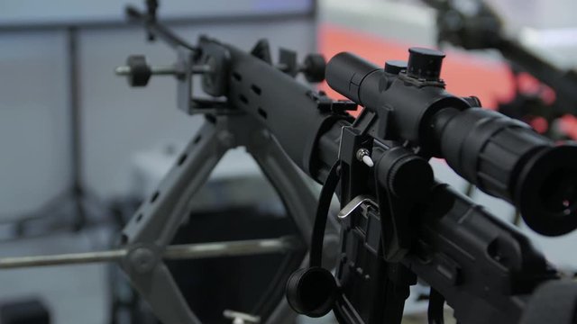 Black sniper rifle modern weapon with an optical sight military green camouflage camera movement