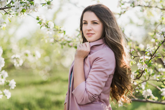 Long hair girl in blooming garden closeup portrait