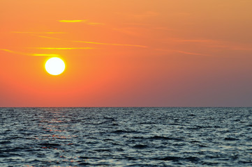 Fototapeta na wymiar Beautiful colorful sunset over wavy waters of Black sea in Crimea