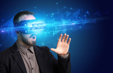 Businessman looking through Virtual Reality glasses with NETWORK OPTIMIZATION inscription, cyber security concept