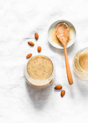 Honey, almonds, dates, apples, almond milk protein smoothies on a light background. Healthy diet protein drink