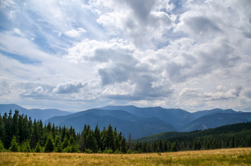 Beautiful scenic landscape of one of the mountain ranges of the Carpathians with mountains, and forest on the background of sky with clouds, Ukraine 