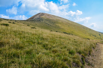 Obraz premium Dirt road uphill in to the mountain peak. Beautiful mountainous landscape in summer. location Svydovets mountain ridge, Carpathian, Ukraine