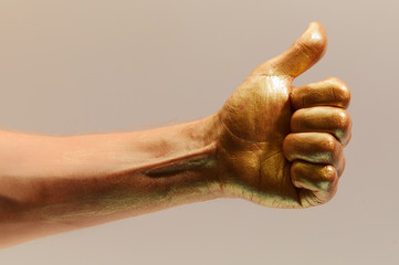 Image of gold painted Like gesture on light beige background