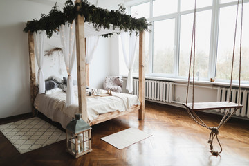 Spacious bedroom with wood, blankets and bed against a wall. Modern home interior design concept.
