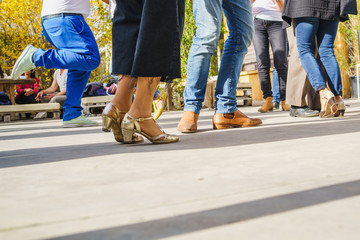 People dancing tango at the summer party. Focus on the feet