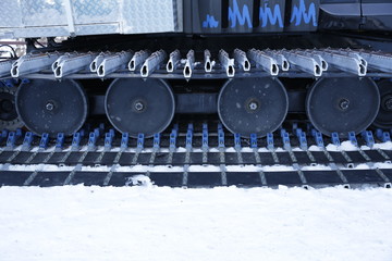 Obraz na płótnie Canvas Tracked wheels with spikes. Details of an all-terrain vehicle, snow blower, snowplow, snowmobile. The car for winter off road and extreme conditions.