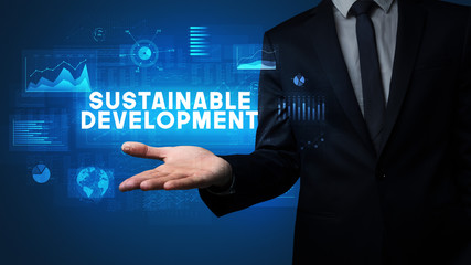 Hand of Businessman holding SUSTAINABLE DEVELOPMENT inscription, business success concept