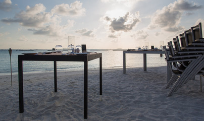 table setting on a resort beach at sunset