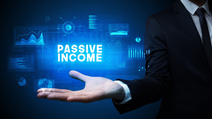 Hand of Businessman holding PASSIVE INCOME inscription, business success concept