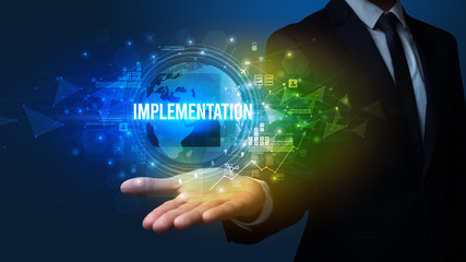 Elegant hand holding IMPLEMENTATION inscription, digital technology concept