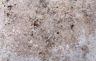 The cement floor has smudges, alternating gray, with holes on the ground