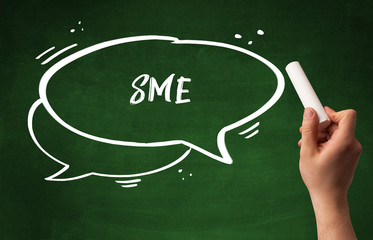 Hand drawing SME abbreviation with white chalk on blackboard